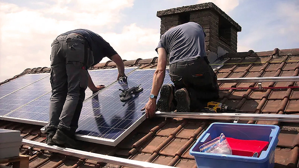 En primavera dos hombres instalan placas solares